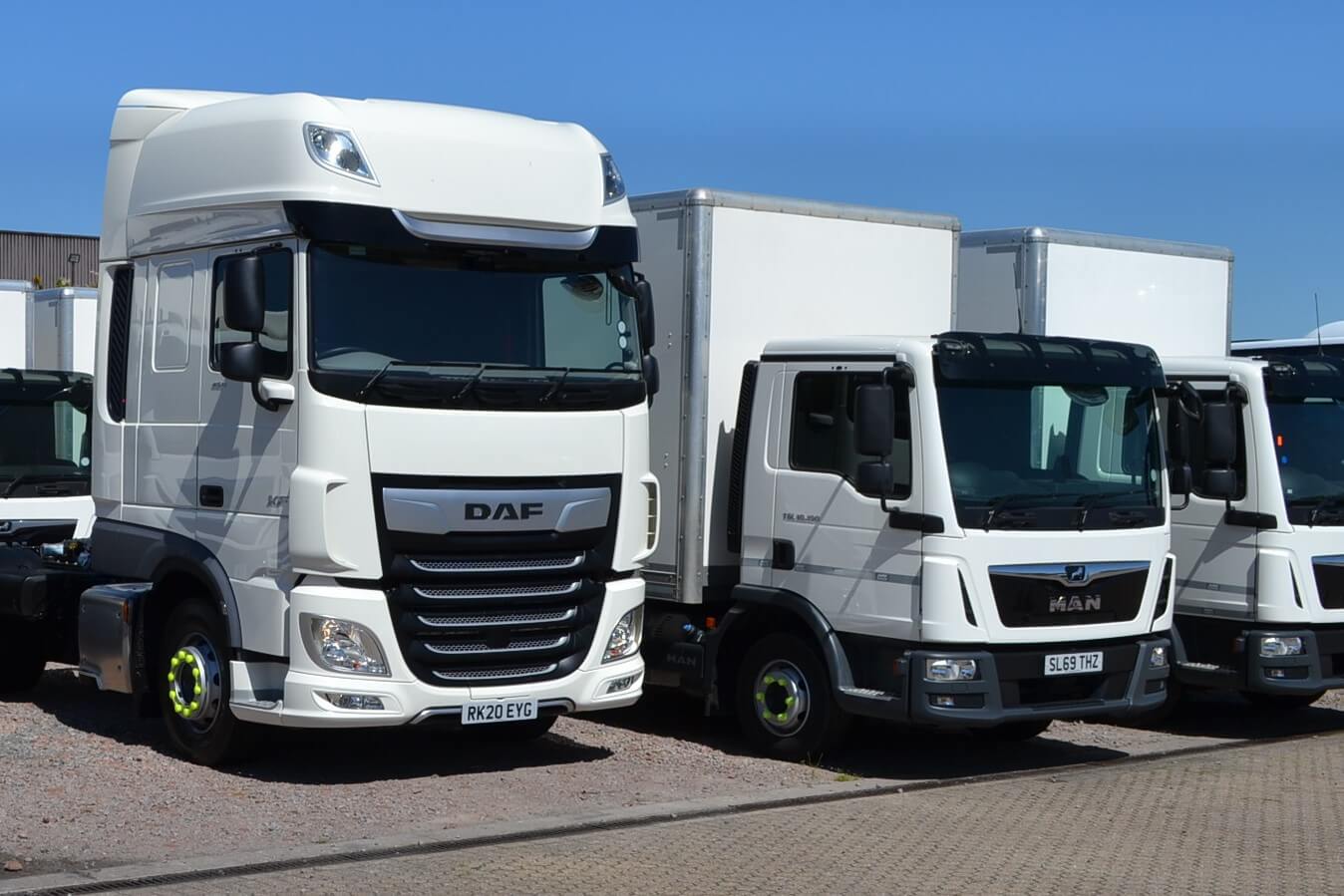 Three white trucks lined up next to each other